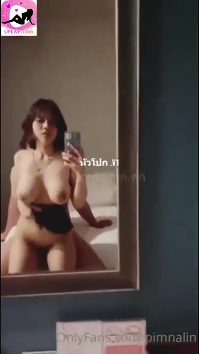 (Thai) Nong Magic sits rocking with her husband on the bed.